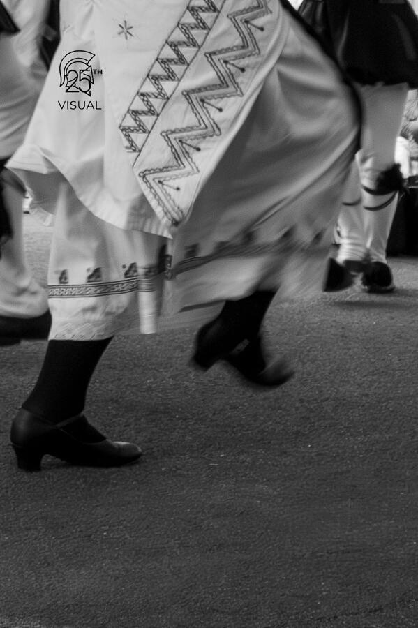 The quick movement of a traditional greek dance captured in black & white.